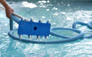 Man holding an equipment for cleaning swimming pool