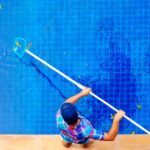 man cleaning pool