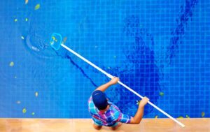 man cleaning pool